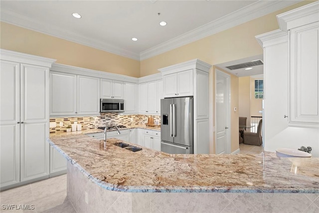 kitchen featuring crown molding, light stone countertops, appliances with stainless steel finishes, and a sink