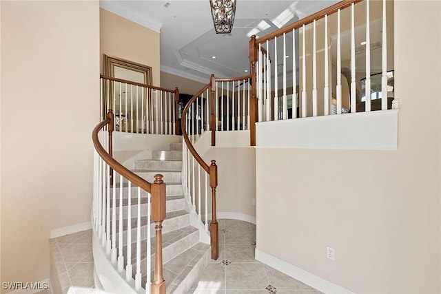 stairway with tile patterned floors, baseboards, and crown molding