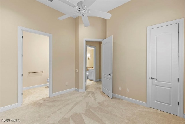 unfurnished bedroom featuring ensuite bath, baseboards, and light carpet