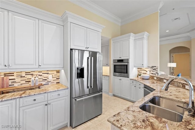 28551 Calabria Ct Unit 202, Naples, FL 34110 - kitchen featuring visible vents, arched walkways, a sink, ornamental molding, and stainless steel appliances