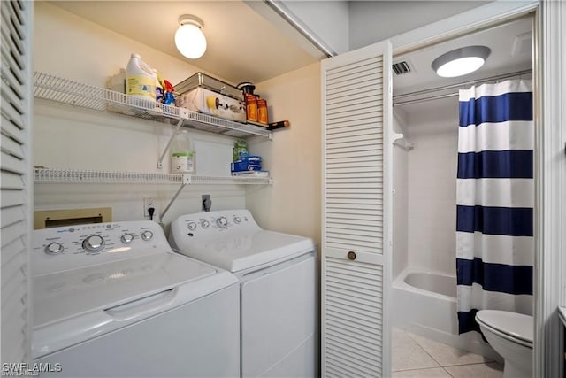 laundry area featuring light tile patterned floors and washing machine and dryer