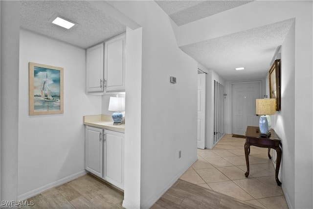 7430 Lake Breeze Dr Unit 402, Fort Myers, FL 33907 - hall with a textured ceiling, baseboards, and light wood finished floors