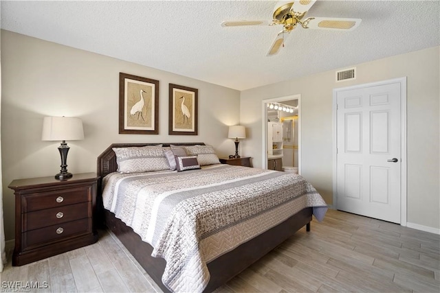 bedroom featuring a textured ceiling, light wood-type flooring, ensuite bathroom, and ceiling fan