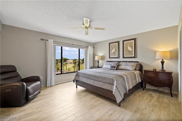 7430 Lake Breeze Dr Unit 402, Fort Myers, FL 33907 - bedroom featuring light wood-style flooring, baseboards, a textured ceiling, and ceiling fan