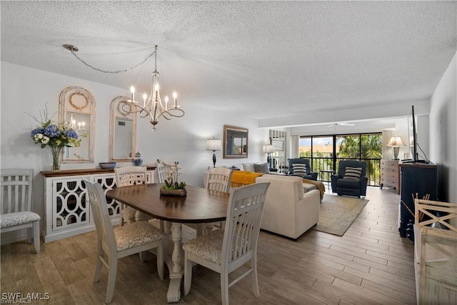 7430 Lake Breeze Dr Unit 402, Fort Myers, FL 33907 - dining area with a textured ceiling, wood finished floors, and a chandelier