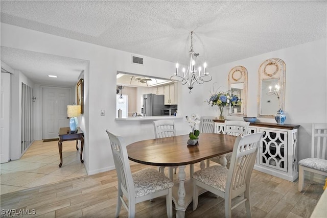 7430 Lake Breeze Dr Unit 402, Fort Myers, FL 33907 - dining room with a textured ceiling, a chandelier, and light wood finished floors