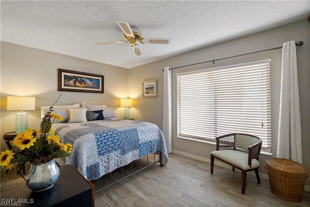 7430 Lake Breeze Dr Unit 402, Fort Myers, FL 33907 - bedroom featuring wood finished floors, baseboards, a textured ceiling, and a ceiling fan