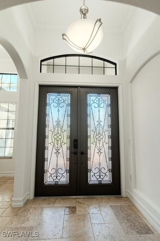 3273 Runaway Ln, Naples, FL 34114 - foyer entrance featuring stone tile floors, french doors, ornamental molding, plenty of natural light, and a high ceiling