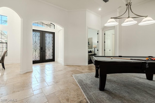 3273 Runaway Ln, Naples, FL 34114 - rec room featuring arched walkways, stone tile floors, baseboards, crown molding, and a towering ceiling