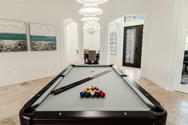 3273 Runaway Ln, Naples, FL 34114 - recreation room featuring arched walkways, a chandelier, pool table, and stone finish flooring