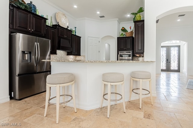 kitchen with french doors, stainless steel appliances, tasteful backsplash, light stone counters, and crown molding