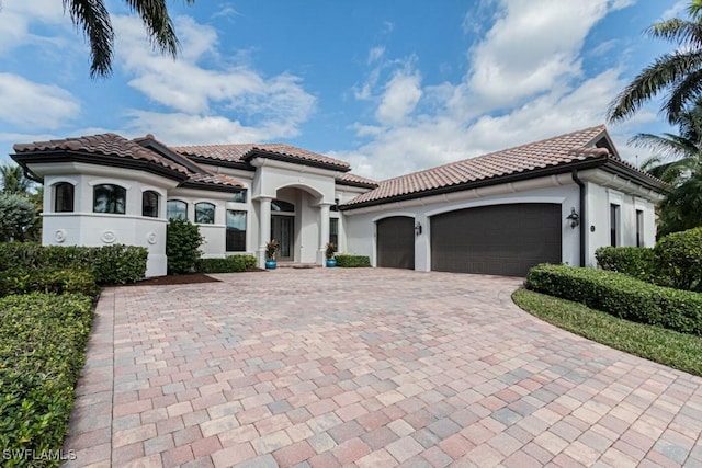 3273 Runaway Ln, Naples, FL 34114 - mediterranean / spanish home featuring a tile roof, decorative driveway, an attached garage, and stucco siding