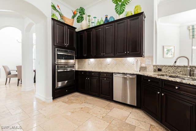 kitchen with backsplash, sink, ornamental molding, light stone counters, and stainless steel appliances