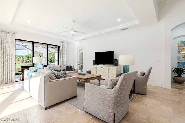 living room with ceiling fan, a raised ceiling, and crown molding