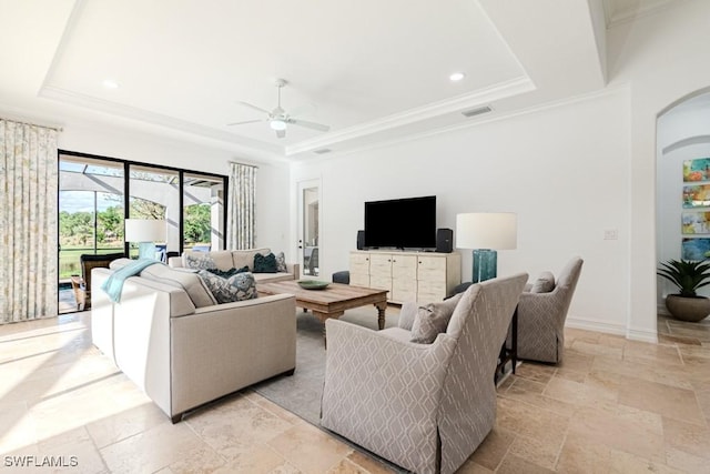 3273 Runaway Ln, Naples, FL 34114 - living area with a raised ceiling, stone tile flooring, ceiling fan, arched walkways, and ornamental molding