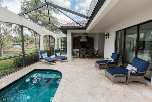 view of swimming pool with ceiling fan, a patio, and glass enclosure