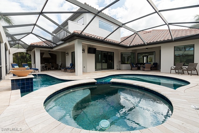 back of house featuring glass enclosure, ceiling fan, a patio area, and a pool with hot tub