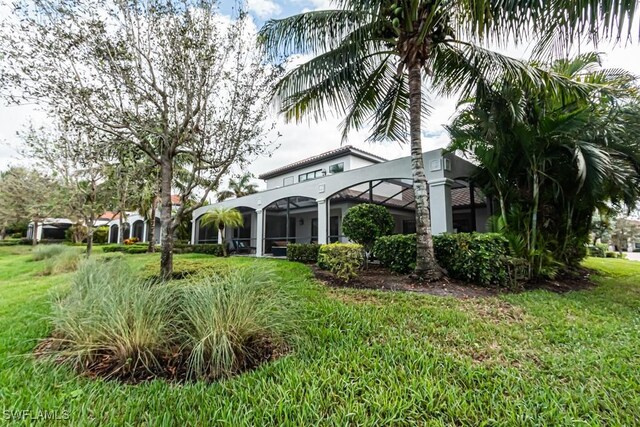3273 Runaway Ln, Naples, FL 34114 - view of side of property with stucco siding, glass enclosure, and a yard