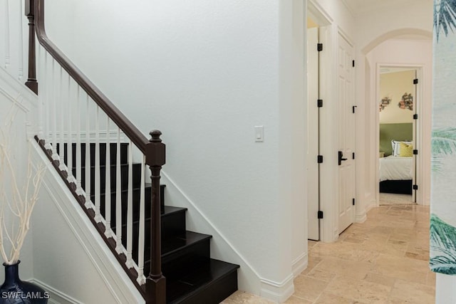 3273 Runaway Ln, Naples, FL 34114 - staircase featuring stone tile flooring, arched walkways, and baseboards