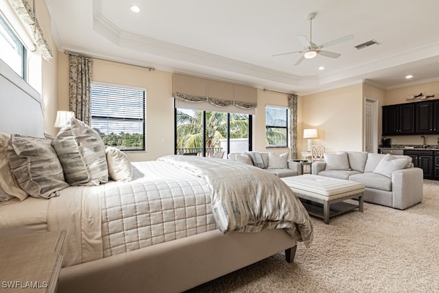 bedroom featuring ceiling fan, light colored carpet, crown molding, and a tray ceiling