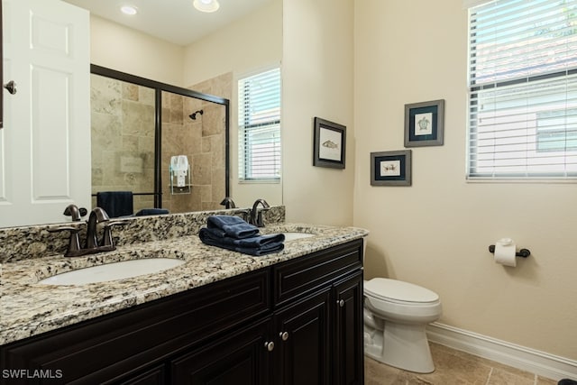 bathroom featuring tile patterned flooring, vanity, toilet, and a shower with door