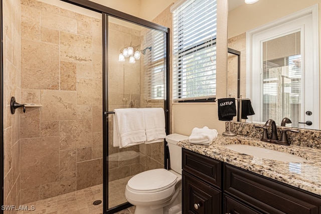 bathroom with vanity, an enclosed shower, and toilet