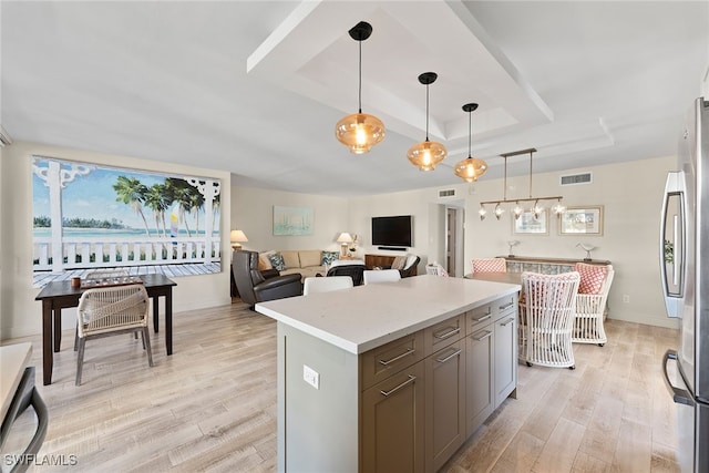 kitchen with stainless steel appliances, a center island, light hardwood / wood-style floors, and decorative light fixtures