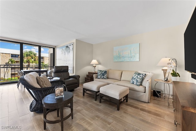 living room with floor to ceiling windows and light wood-type flooring