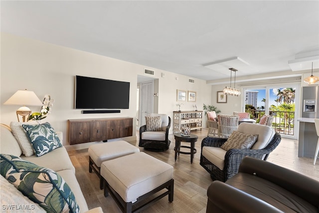 living room featuring light hardwood / wood-style flooring and a notable chandelier