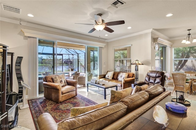 living room featuring crown molding, plenty of natural light, light tile patterned floors, and ceiling fan with notable chandelier