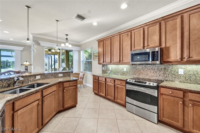 kitchen with sink, crown molding, appliances with stainless steel finishes, decorative light fixtures, and light stone counters