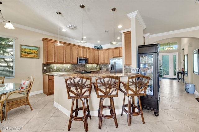 kitchen with pendant lighting, crown molding, light stone countertops, appliances with stainless steel finishes, and kitchen peninsula