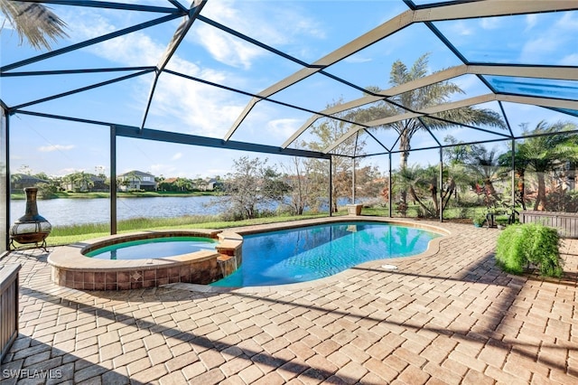 view of pool with a patio, a lanai, an in ground hot tub, and a water view