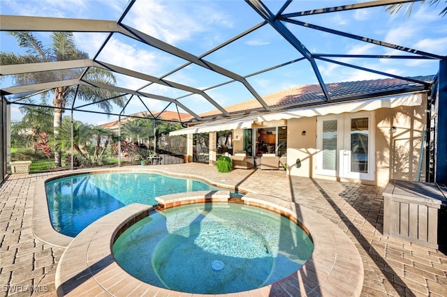 view of pool with glass enclosure, a patio area, an in ground hot tub, and french doors