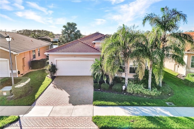 mediterranean / spanish home featuring a garage and a front lawn