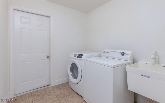 washroom with washing machine and dryer, sink, and light tile patterned floors