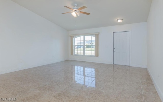 tiled empty room with ceiling fan and lofted ceiling