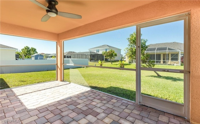 unfurnished sunroom with ceiling fan