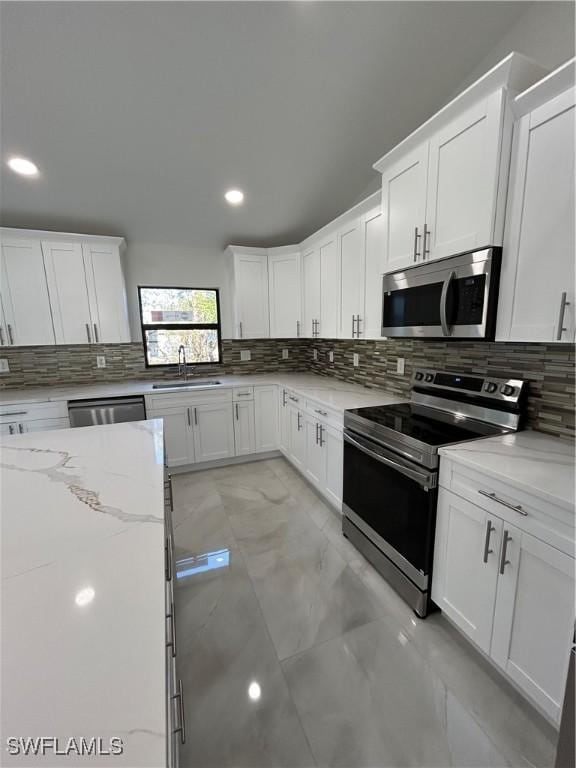 kitchen with white cabinets, light stone counters, and appliances with stainless steel finishes