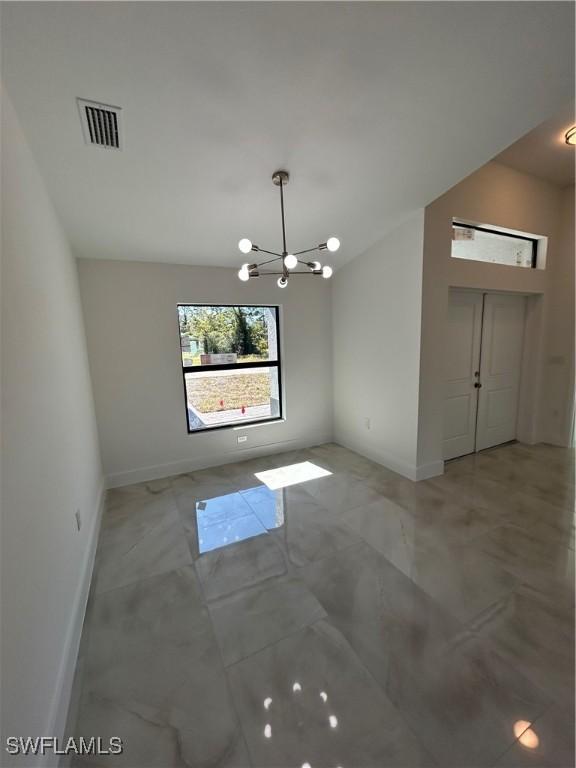 unfurnished dining area with a chandelier