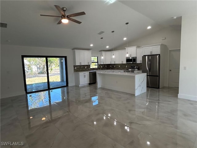 kitchen with stainless steel appliances, white cabinets, a center island, decorative light fixtures, and ceiling fan