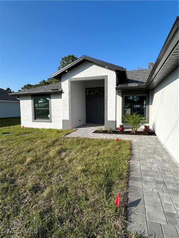 view of exterior entry with a lawn