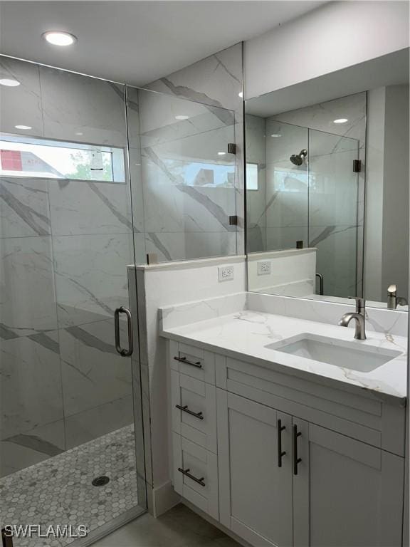 bathroom with an enclosed shower and vanity