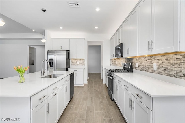 kitchen with white cabinets, decorative light fixtures, and stainless steel appliances