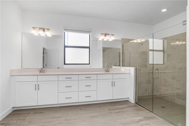 bathroom featuring vanity and a shower with door