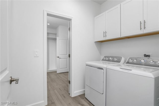 clothes washing area featuring cabinets, independent washer and dryer, and light wood-type flooring