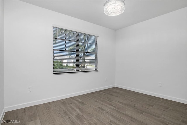 empty room featuring hardwood / wood-style floors and an inviting chandelier