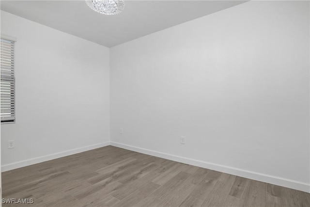 empty room featuring hardwood / wood-style floors and a chandelier