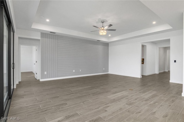 unfurnished room featuring ceiling fan and a tray ceiling