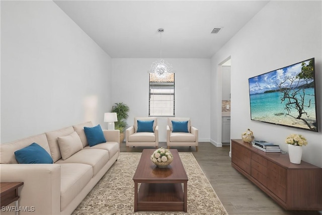 living room featuring light wood-type flooring and a notable chandelier